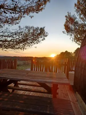 a wooden picnic table with a sunset in the background at Domaine de Villemus in Jouques