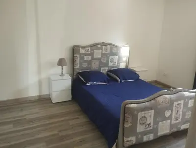 a bedroom with a bed with a blue comforter at les oliviers in Carpentras