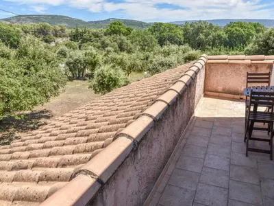 a stone wall with a table and chairs on a patio at Villa La Chênaie by Interhome in Saumane-de-Vaucluse