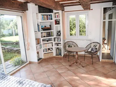 a room with a table and chairs and bookshelves at Villa La Chênaie by Interhome in Saumane-de-Vaucluse