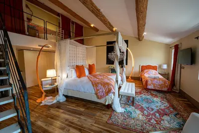 a bedroom with a canopy bed and a staircase at Le Clos Violette et Le 11 D'Aglaé - Appart' Hôtel de Charme Design de Luxe in LʼIsle-sur-la-Sorgue