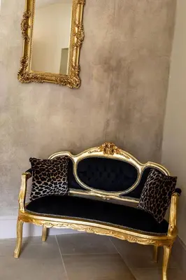 a gold and black couch in front of a mirror at Le Clos Violette et Le 11 D'Aglaé - Appart' Hôtel de Charme Design de Luxe in LʼIsle-sur-la-Sorgue