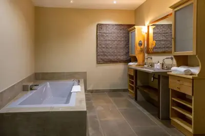 a bathroom with a large tub and a sink at Le Clos Violette et Le 11 D'Aglaé - Appart' Hôtel de Charme Design de Luxe in LʼIsle-sur-la-Sorgue