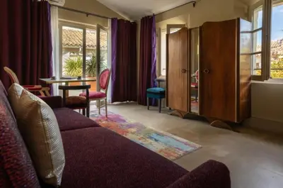 a living room with a couch and a table at Le Clos Violette et Le 11 D'Aglaé - Appart' Hôtel de Charme Design de Luxe in LʼIsle-sur-la-Sorgue