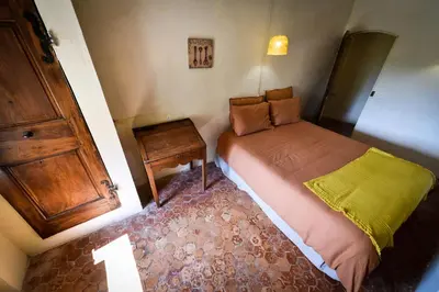 a small bedroom with a bed and a wooden cabinet at la bastide de l'adrech in Manosque