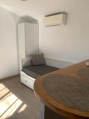 a room with a bed and a table with a chair at studio avec exterieur in Eyragues