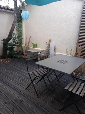 a table and chairs on a wooden deck at studio avec exterieur in Eyragues
