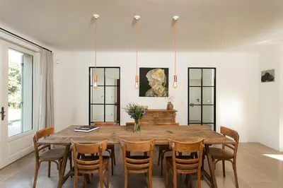 a dining room with a wooden table and chairs at Les Amandiers in Bonnieux