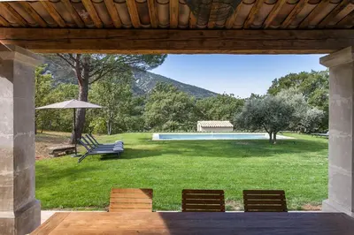 a view of a yard with a bench and a pool at Les Amandiers in Bonnieux
