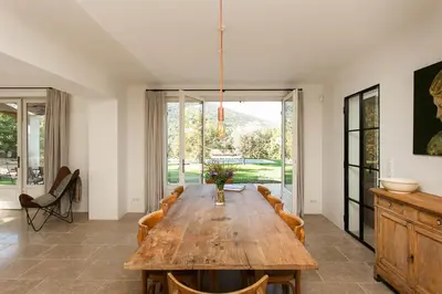 a dining room with a wooden table and chairs at Les Amandiers in Bonnieux