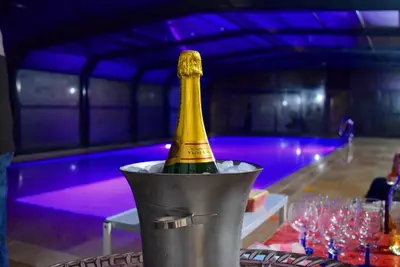 a bottle of champagne in a bucket on a table at Au Murmure de la Sorgue in LʼIsle-sur-la-Sorgue