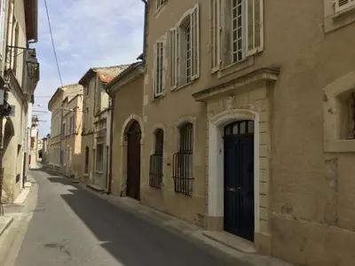 an alley in an old building with a black door at Maison de village Novissime in Noves