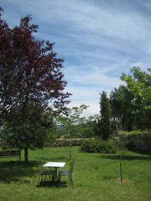 a picnic table and two chairs in a field at La Fenice - Beautifully restored property with heated pool in small village in Montjustin