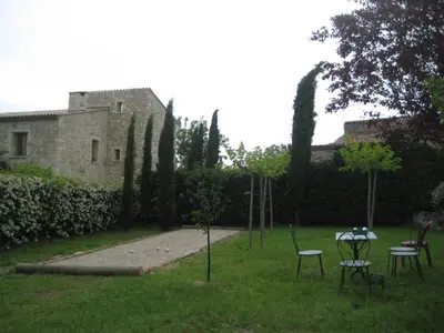 a garden with chairs and a swing set in the grass at La Fenice - Beautifully restored property with heated pool in small village in Montjustin