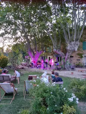 a group of people sitting in chairs in a yard at Mas de Karlotte in Pernes-les-Fontaines