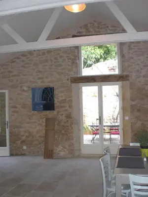 a room with tables and chairs and a stone wall at Château de Peyrolles in Apt