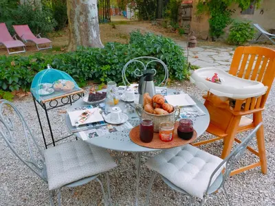 a table with a tea kettle and a bowl of fruit at Rêve d’Emma in Plan-dʼOrgon