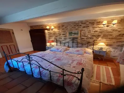 a bedroom with a bed in a room with a stone wall at Provence Charm with Pool in Viens