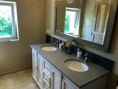 a bathroom with two sinks and a mirror at Provence Charm with Pool in Viens