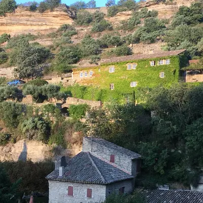a building on the side of a hill at La Calade, maison de village in Gordes