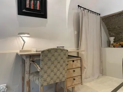 a desk with a chair next to a dresser at La Calade, maison de village in Gordes