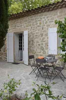 a patio with a table and chairs in front of a building at Moulin des Gypses Gîte Les Pierres Blanches, Ventoux in Mormoiron
