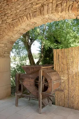 an outdoor wood stove sitting under a stone wall at Le Champ des Oliviers in Oppède