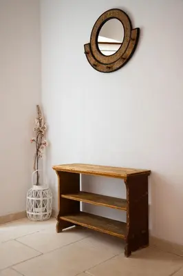 a wooden table with a mirror on a wall at Le Champ des Oliviers in Oppède