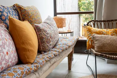 a couch with pillows on it in a living room at Le Champ des Oliviers in Oppède