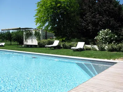 a swimming pool with two lounge chairs next to a yard at Villa Melodie St Remy 6HA Piscine in Saint-Rémy-de-Provence