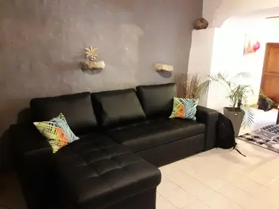 a black leather couch in a living room at Fleur des îles in Saint-Michel-lʼObservatoire
