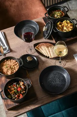 a wooden table with plates of food and glasses of wine at Domaine du Val de Sault in Sault-de-Vaucluse
