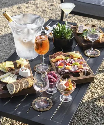 a black table topped with wine glasses and appetizers at Domaine du Val de Sault in Sault-de-Vaucluse