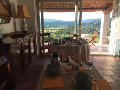 a dining room with a table with a view at Le Logis in Gordes