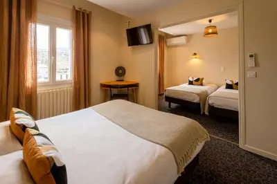 a hotel room with two beds and a window at L'Aptois Hôtel in Apt