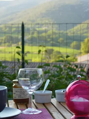 a wine glass sitting on top of a wooden table at Chambre d'hôtes face au lavoir in Méthamis