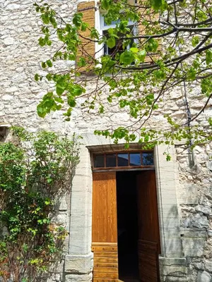a building with a wooden door and a window at Chambre d'hôtes face au lavoir in Méthamis