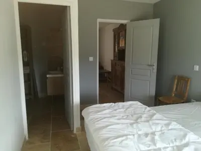 a bedroom with a white bed and a bathroom at Au pays du Ventoux in Le Thor