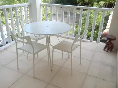 a white table and four chairs on a porch at Au pays du Ventoux in Le Thor