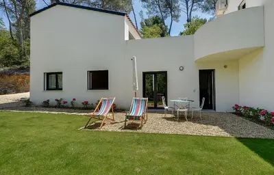 two chairs and a table in front of a house at Maison du Prignon in Saint-Marc-Jaumegarde