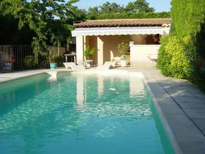 a swimming pool in a yard next to a house at Gite des Taillades in Les Taillades