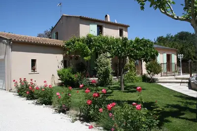 a garden in front of a house with roses at Gite des Taillades in Les Taillades