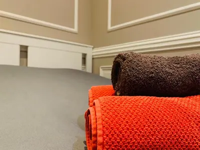 an orange couch with a black pillow sitting in a room at Zola Studio fenêtre aveugle in Aix-en-Provence