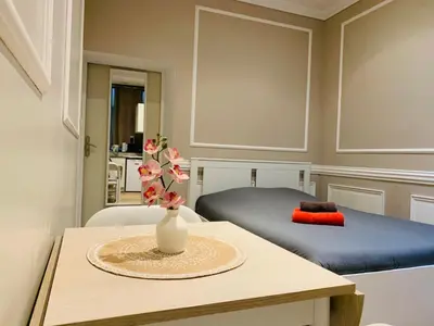 a room with a bed and a table with a vase on it at Zola Studio fenêtre aveugle in Aix-en-Provence