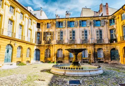 a large building with a fountain in front of it at Victoire Appartement in Aix-en-Provence
