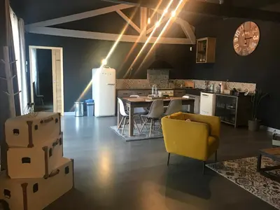 a living room with a yellow chair and a table at Loft piscine et spa provence in LʼIsle-sur-la-Sorgue