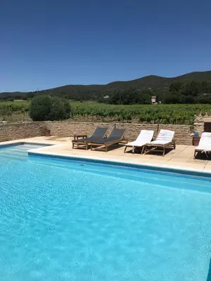 a swimming pool with two lounge chairs at Mas Bastide st Victor à 5 mn de Lourmarin in Puyvert