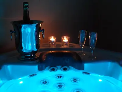 a bath tub with a bottle of wine and glasses at Les Grandes Terres - Gîtes & SPA in Mérindol