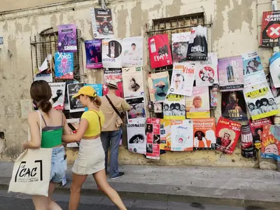 two women walking down a street looking at magazines at Gîte en Provence ''Rose'' in Modène