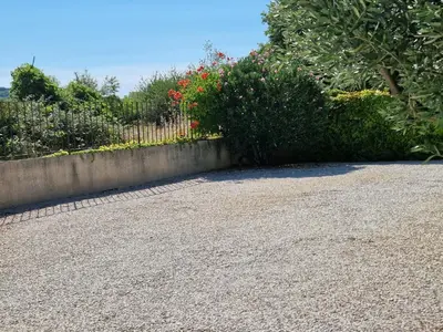 a garden with a fence and some bushes at La Parenthèse in Lauris